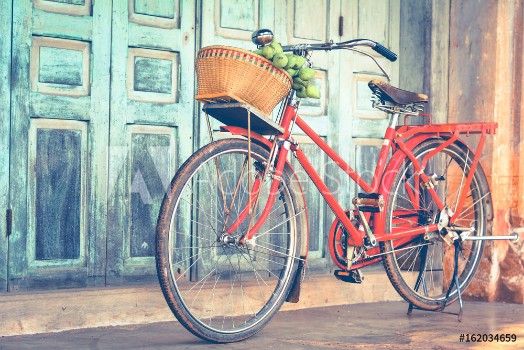 Picture of Hipster red bicycle in old building walls background color if vintage tone 